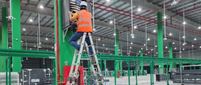 Kỹ thuật viên CPTECH lắp đặt tủ mạng trên cột tại kho xưởng